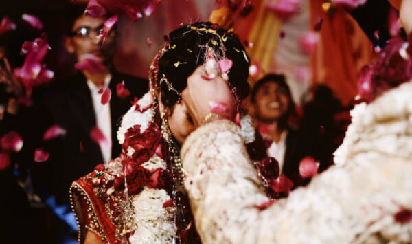 The bride and groom at the Indian wedding garlands or Jaimala ceremony on the stage.